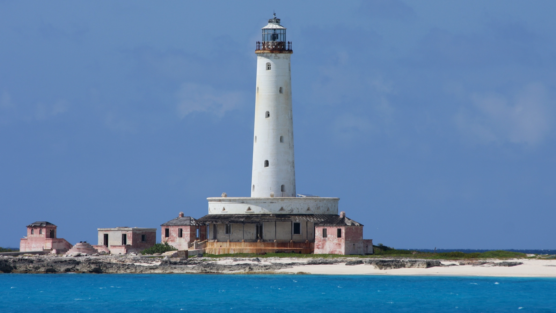 A lighthouse on Crooked Island beside blue water